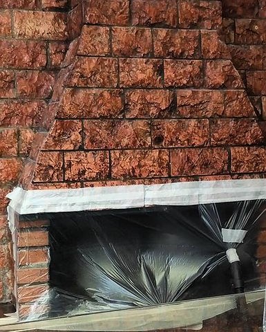 Forno a legna di una pizzeria protetto con telo prima della pulizia della canna fumaria