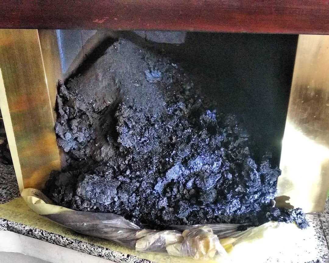 Fuliggine e residui caduti nel caminetto durante la pulizia della canna fumaria