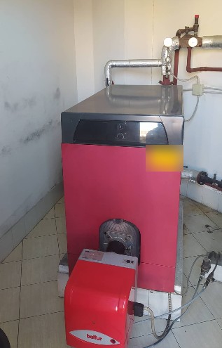 Caldaia a gasolio con bruciatore in un locale caldaia