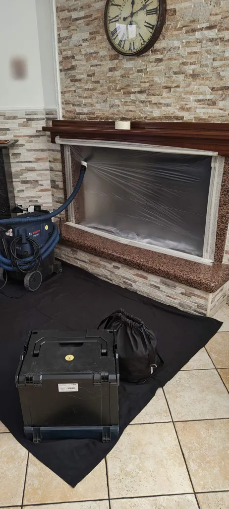 Caminetto con rivestimento in pietra protetto con pellicola, telo e aspiratore