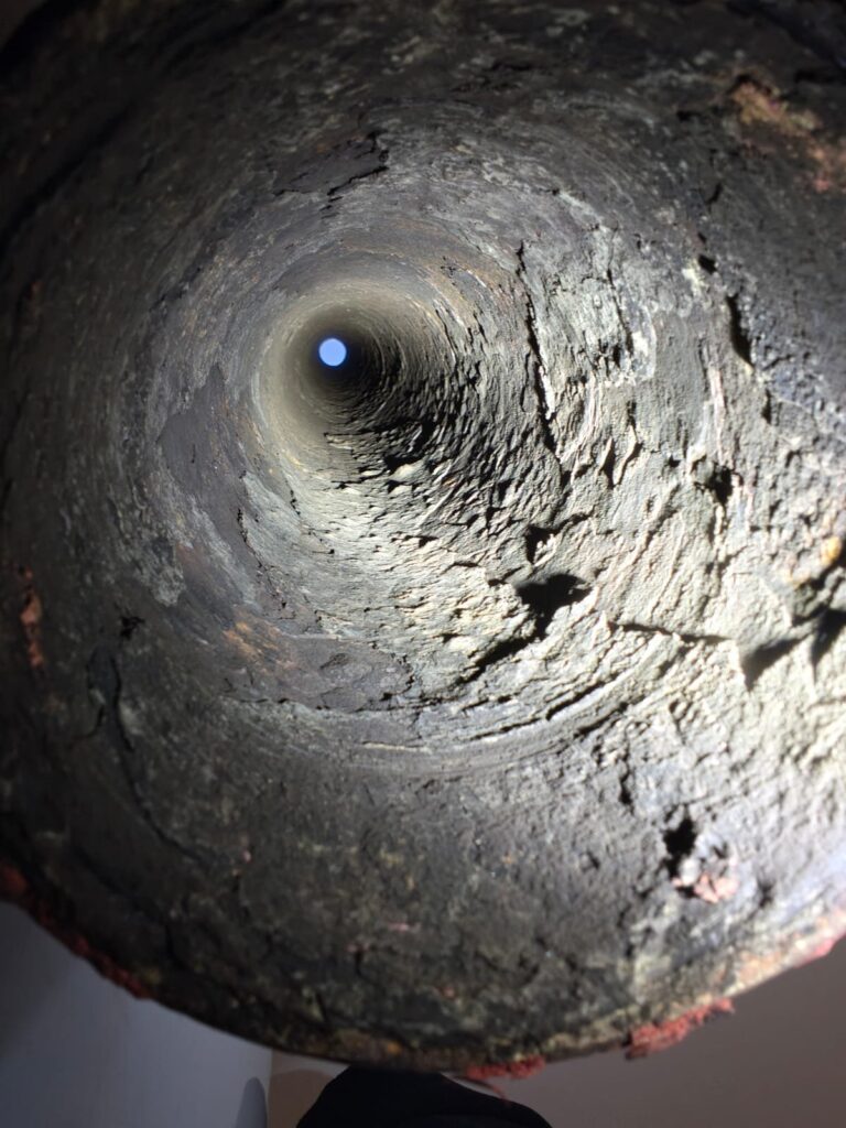 Interno di una canna fumaria con pareti incrostate