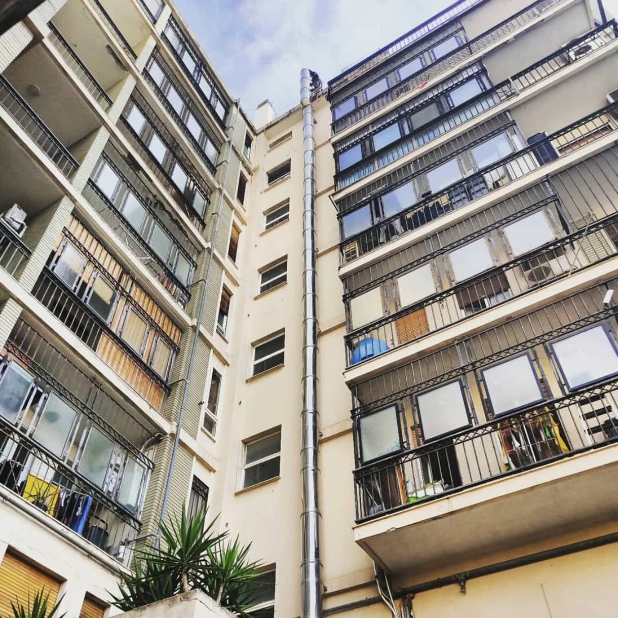 Canna fumaria in acciaio inox lungo la facciata di un condominio