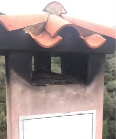 Comignolo con copertura in tegole annerito dal fumo