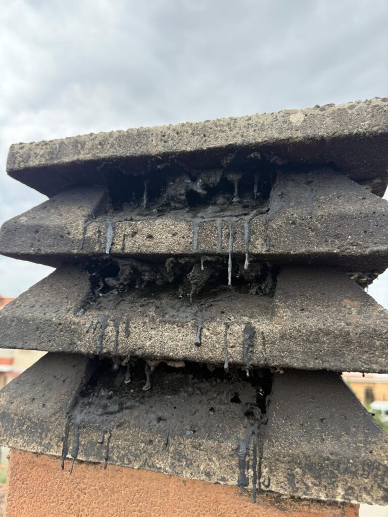 Catrame colato dalle feritoie di un comignolo