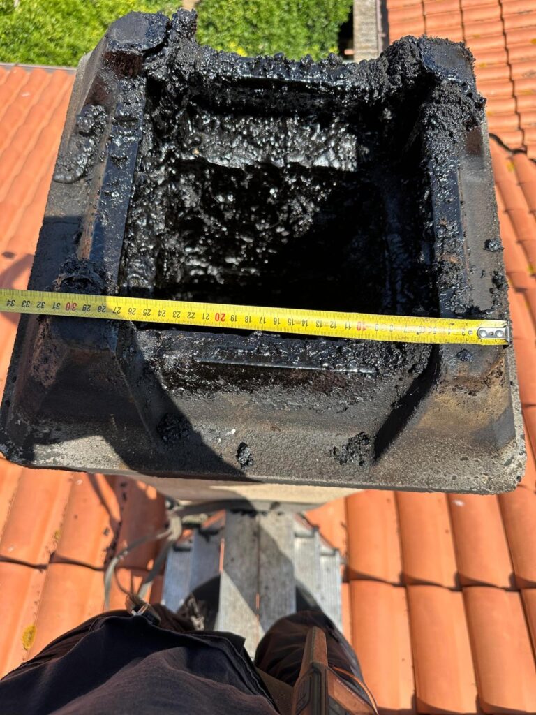 Comignolo pieno di catrame misurato con il metro