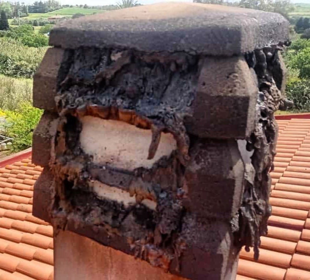 Comignolo in muratura incrostato e rovinato dopo un incendio della canna fumaria