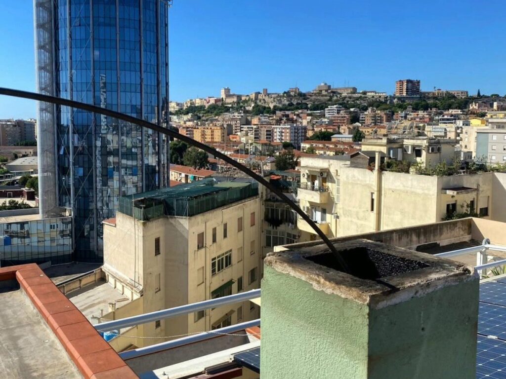 Comignolo sul tetto con la sonda per la pulizia della canna fumaria e il panorama di Cagliari