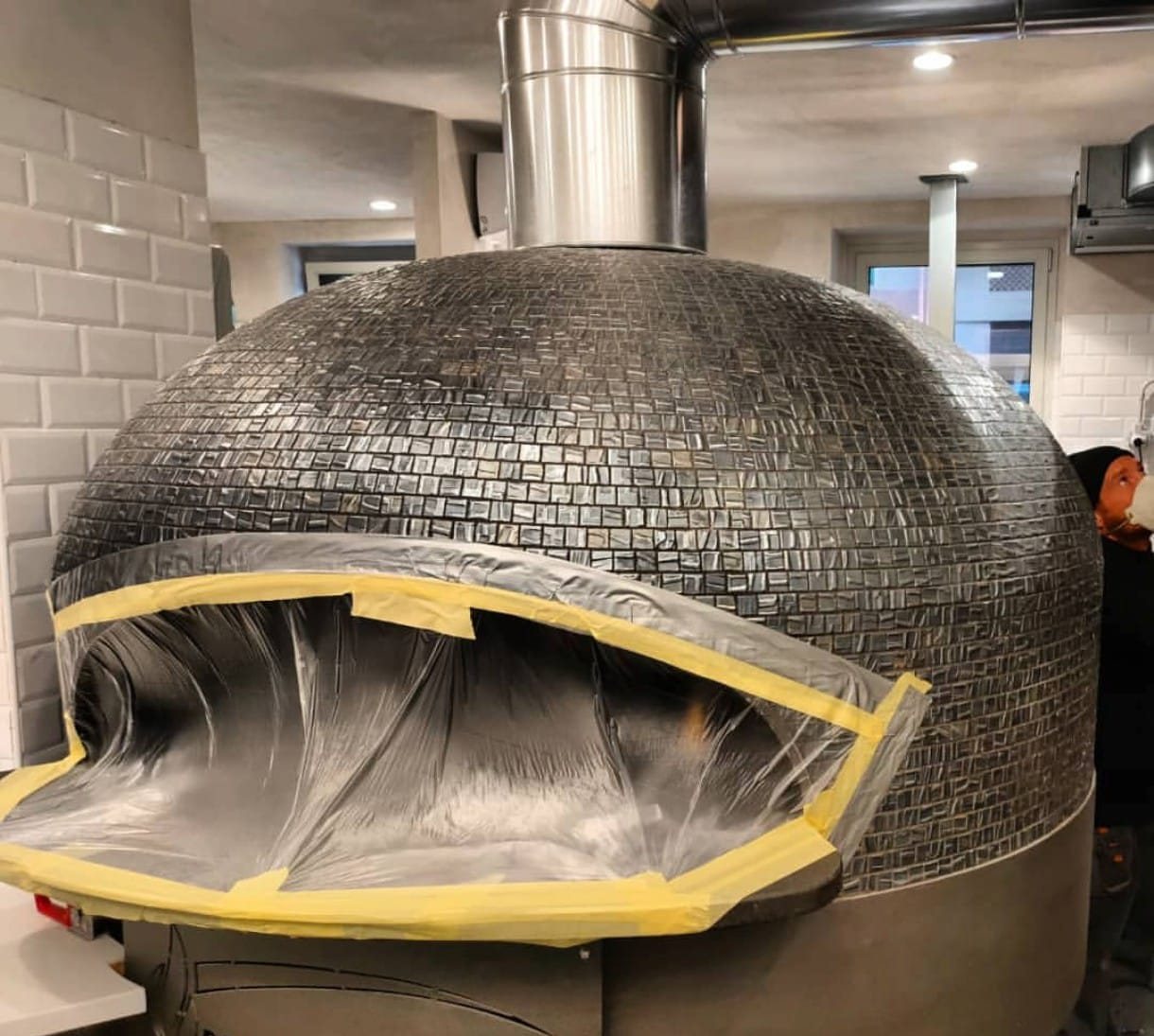 Forno a legna per pizza con la bocca protetta da pellicola durante la pulizia