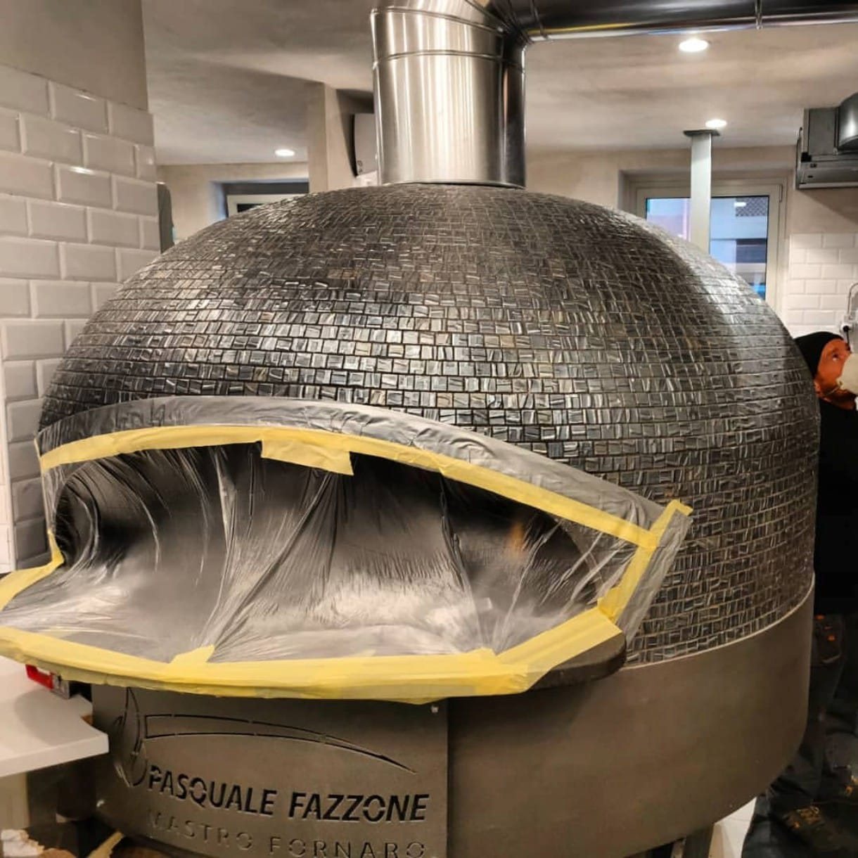 Forno a legna per pizza con la bocca protetta da pellicola durante la pulizia