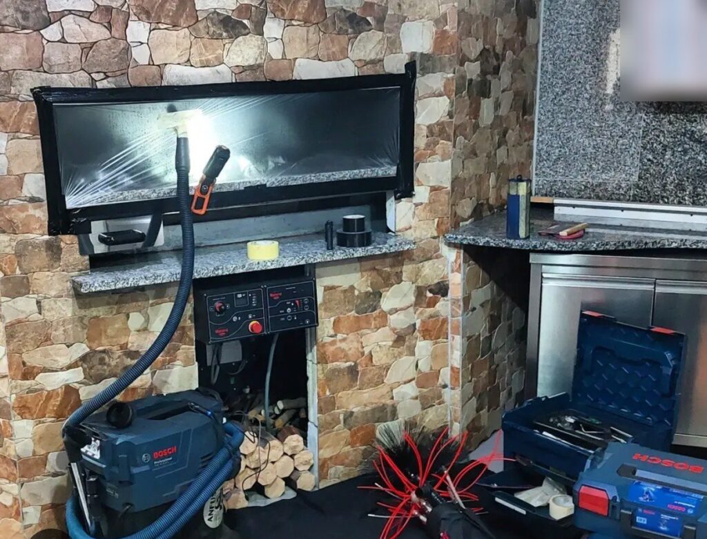 Forno di pizzeria protetto con pellicola, aspiratore e spazzole pronti per la pulizia della canna fumaria